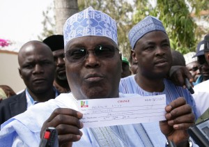 Former Vice President Atiku Abubakar displays his party card as member of APC in his ward in Jada, Adamawa State