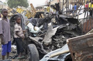 Two boys stand near the charred chassis of a vehicle after a bomb attack near a busy market area in Ajilari-Gomari near the city's airport, in Maiduguri March 2, 2014. At least 10 people were killed after a bomb went off at around 6 p.m. (1700 GMT) on Saturday in a busy market area in Ajilari-Gomari, witnesses and a police source said, in a region where the Islamist sect Boko Haram is pursuing a bloody insurgency. The final death toll was likely to be higher because dozens of people were trapped in the rubble, the witnesses said. 