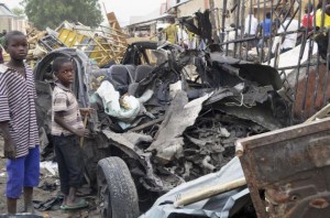 Two boys stand near the charred chassis of a vehicle after a bomb attack near a busy market area in Ajilari-Gomari near the city's airport, in Maiduguri March 2, 2014. At least 10 people were killed after a bomb went off at around 6 p.m. (1700 GMT) on Saturday in a busy market area in Ajilari-Gomari, witnesses and a police source said, in a region where the Islamist sect Boko Haram is pursuing a bloody insurgency. The final death toll was likely to be higher because dozens of people were trapped in the rubble, the witnesses said.