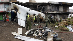 Security personnel attempt to retrieve bodies from wreckage of a cargo plane that crashed into a commercial building on outskirts of Nairobi