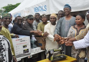 R-L: A beneficiary, Mrs.........,  Vice Chairman, All Progressives Congress, Lagos State, Chief. Funsho Ologunde;  and Chairman, Conference 57 of Lagos State, Mr. Suleiman Hakeem, with other members of the Local Government Chairmen, during the distributions of Empowerment Items to members of the party by Conference 57, of the 30 Local governments and 27 Local  Development Council Area (LCDA), of Lagos State,  at Adeyemi Bero Auditorium, Ikeja, Lagos....yesterday 01-08-14 PHOTO: KOLA OLASUPO